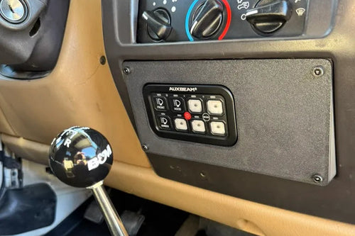 Close-up of a vehicle's gear shift lever and dashboard controls.