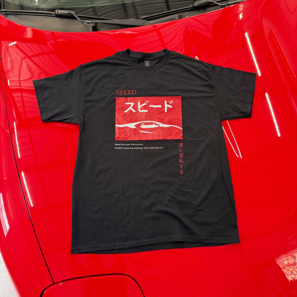 Black t-shirt with red graphic on a red car hood