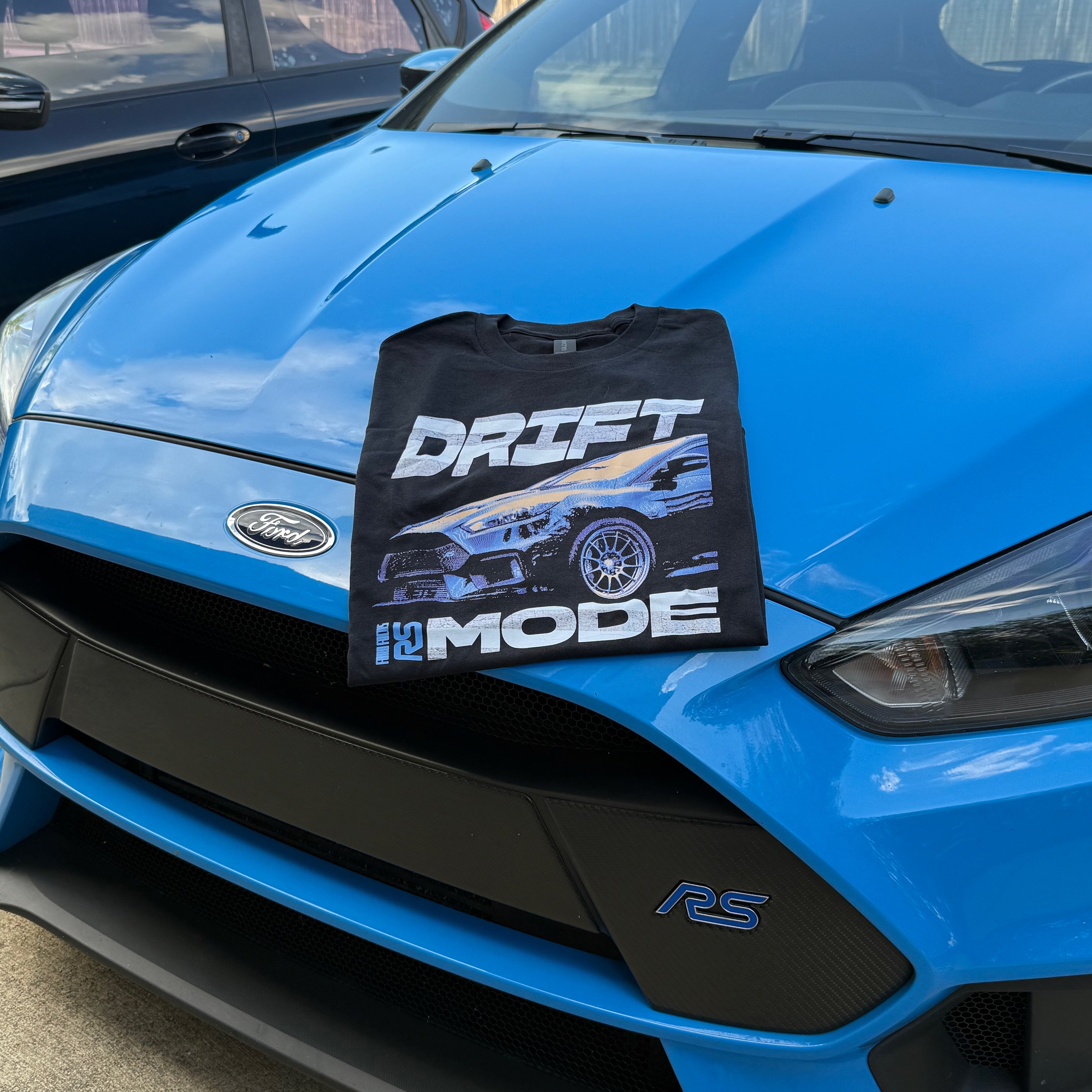 Blue car with a black t-shirt labeled 'DRIFT MODE' on the hood