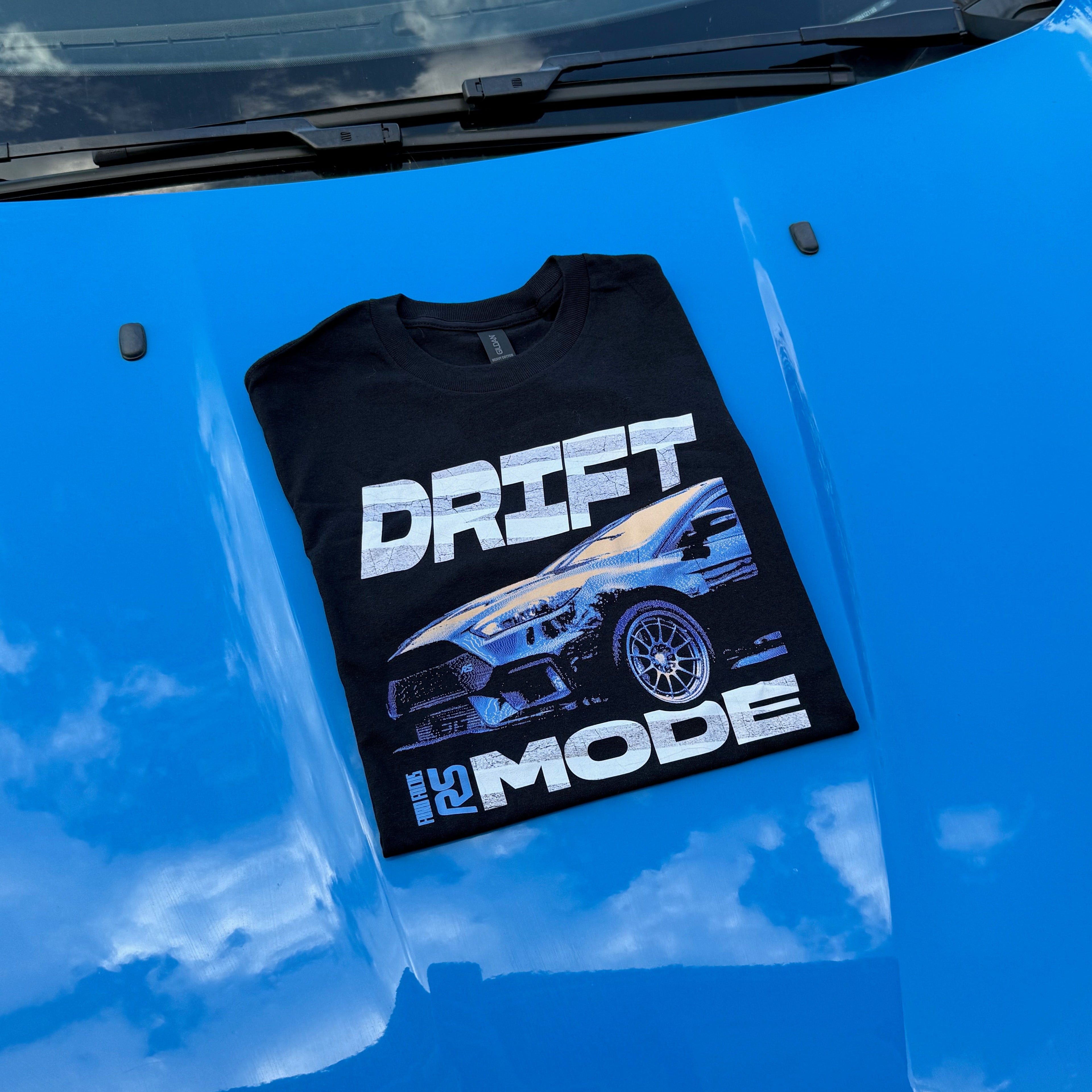 Black t-shirt with 'DRIFT MODE' graphic on a blue car hood